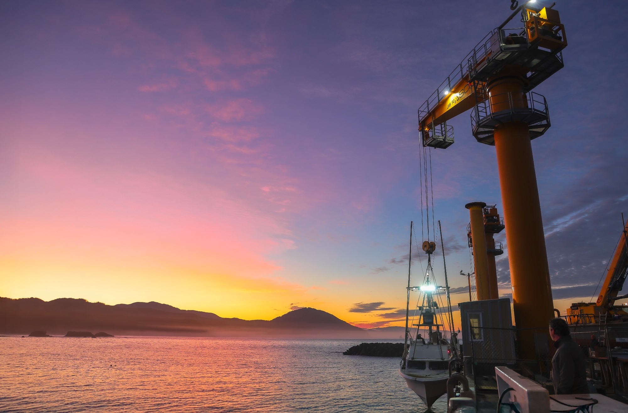 Port Orford boat hoist and fishing vessel at sunset
