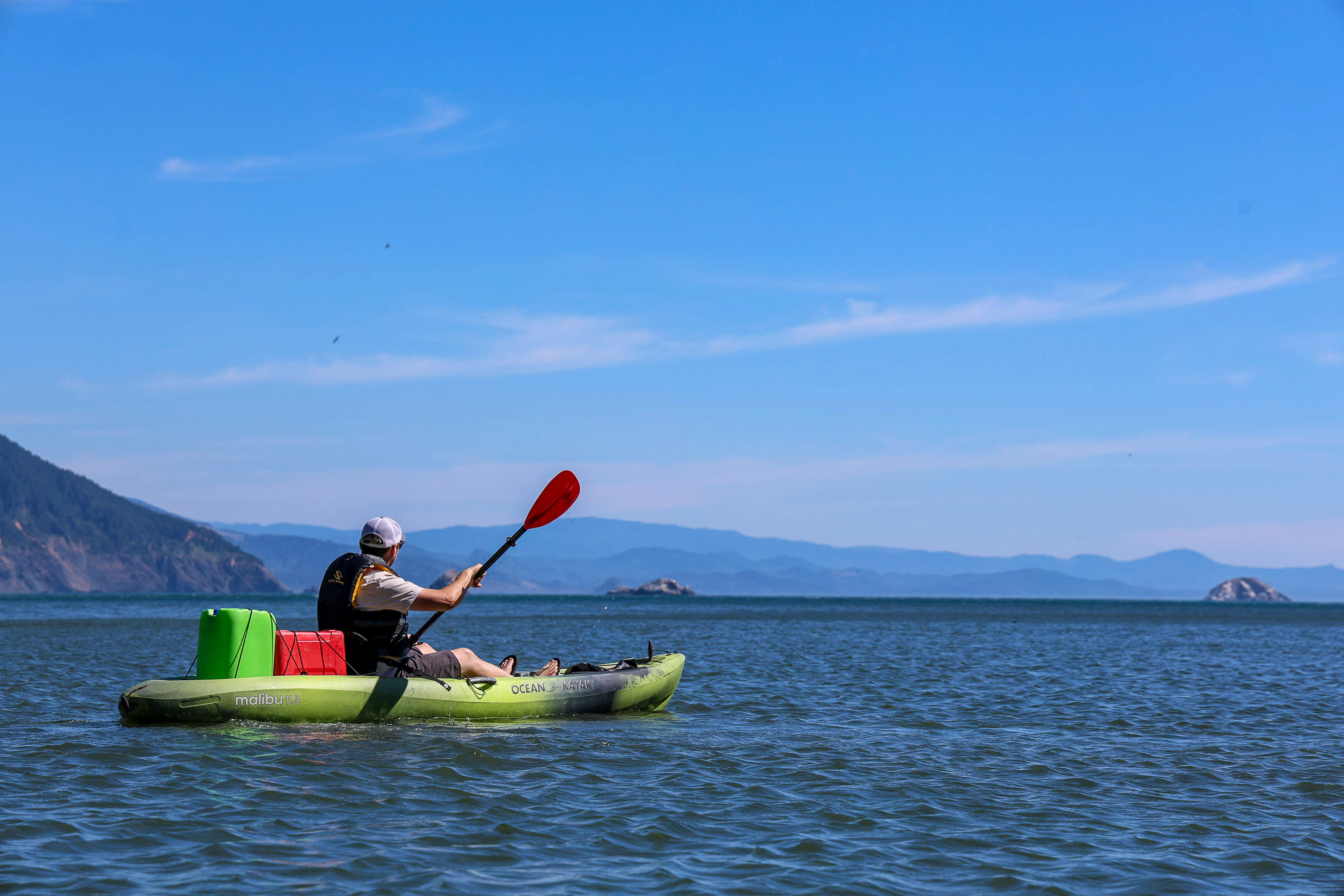 Kayaker paddling calm waters off the Southern Oregon Coast