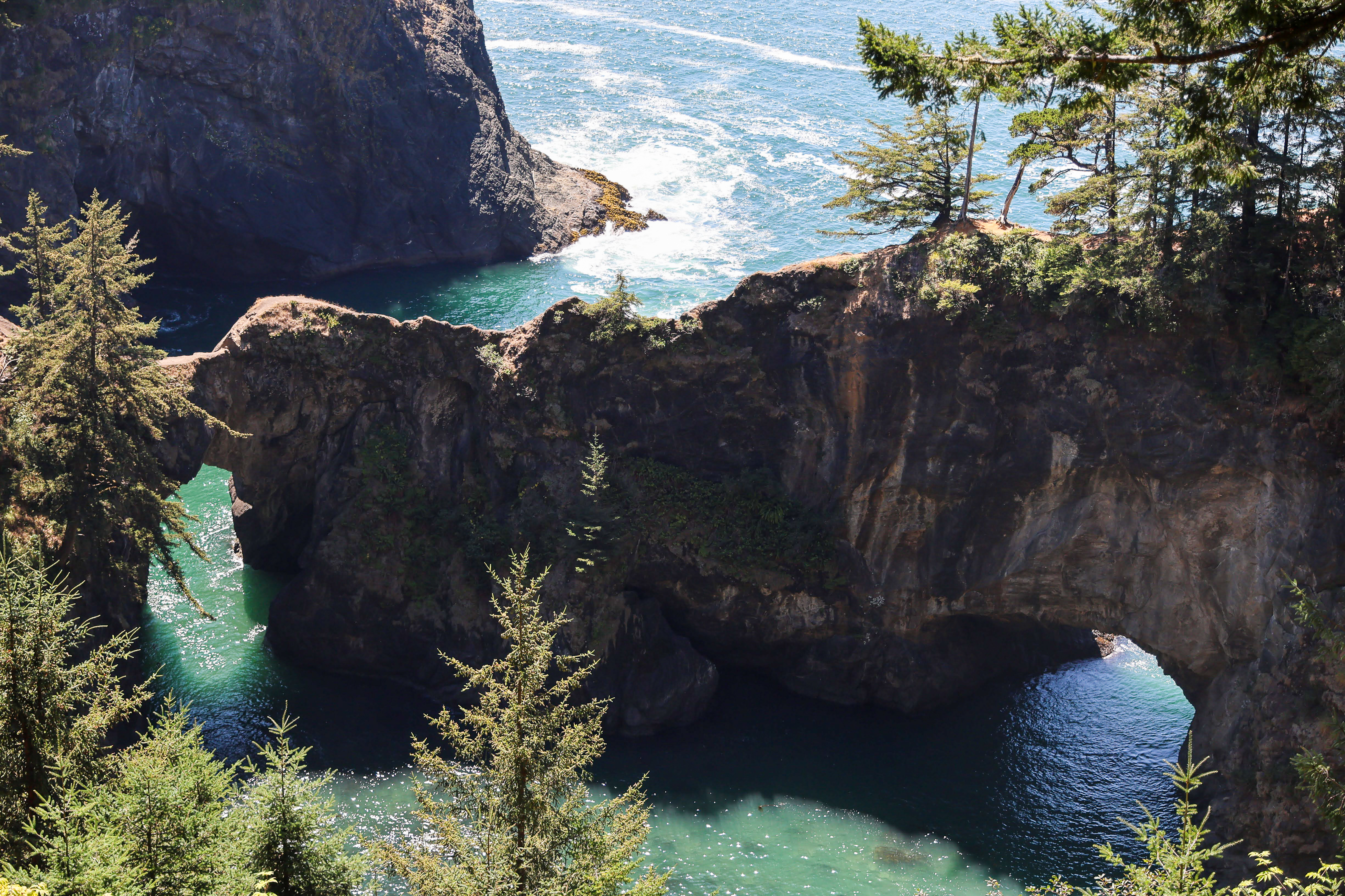 Natural Bridges rock arch with turquoise water on the Southern Oregon Coast