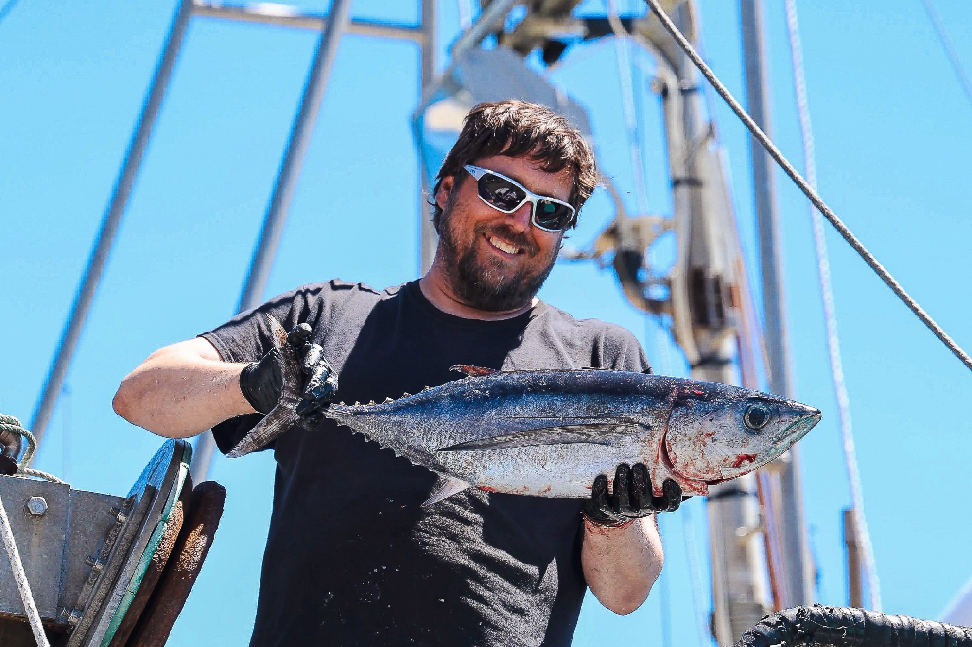 Fisherman holding fresh tuna on a Port Orford fishing boat